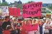 Photograph of protesters with signs about cuts in school spending