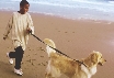 Photograph of a teenage boy walking a dog on a leash