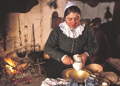 Photograph of a woman reenacting work in a Pilgrim's kitchen