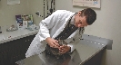 Photograph of a male veterinarian examining a small animal