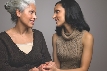 Photograph of two women holding hands in comfort